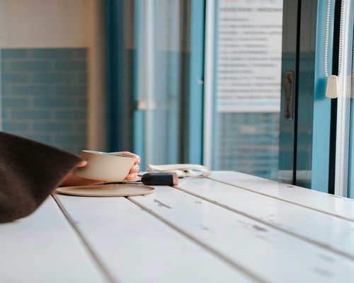 Close up of a person taking a screen break, looking outside while holding a cup of coffee
